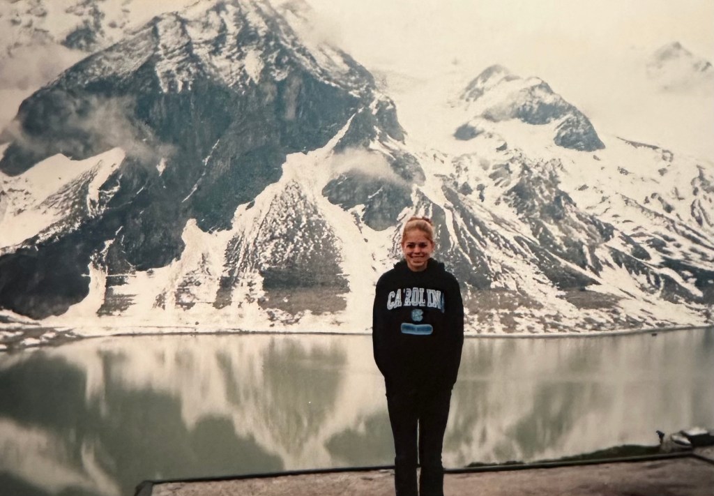 Jules at 15 years old wearing a UNC hoodie in front of the Alps in Austria 