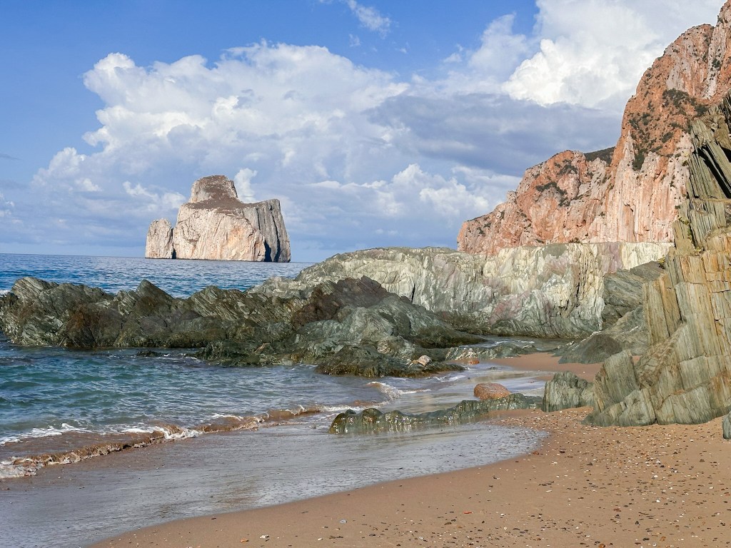 A view of the Pan di Zucchero sea stacks from the beach in Sardinia, Italy. 