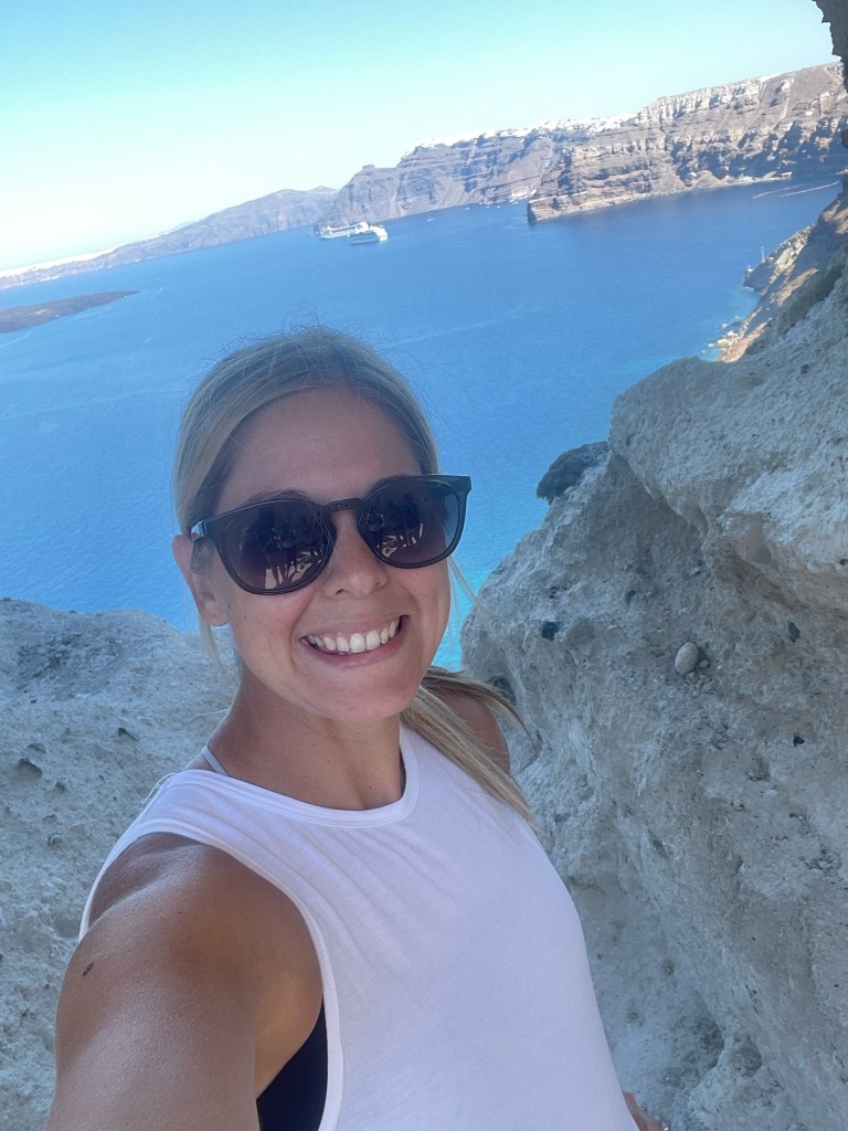 Jules, travel blogger, mother and pilot wife, taking a selfie in The Heart of Santorini