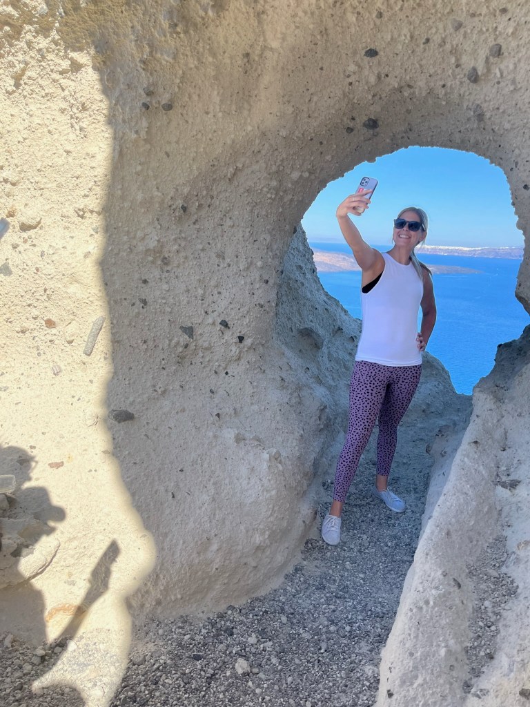 Jules, travel blogger, mother and pilot wife, taking a selfie in The Heart of Santorini