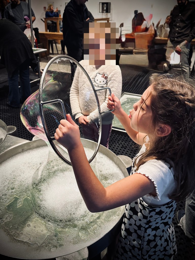 6 year old blowing bubbles at NEMO Science Museum