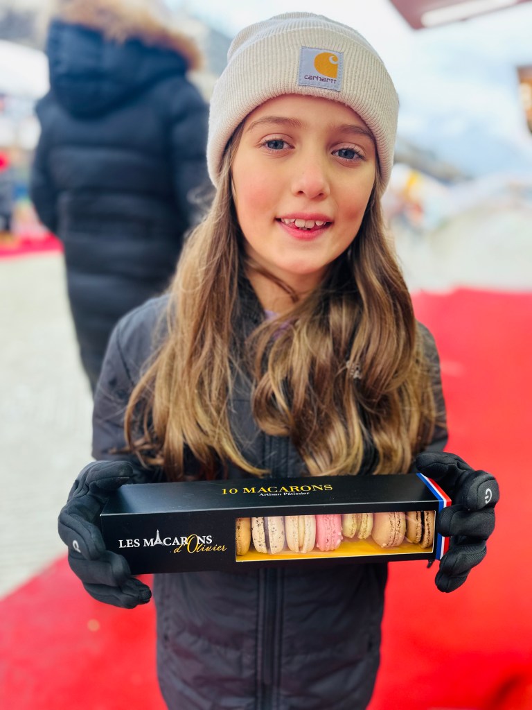 Daughter holding box of macarons at Christmas market in Tuileries Garden