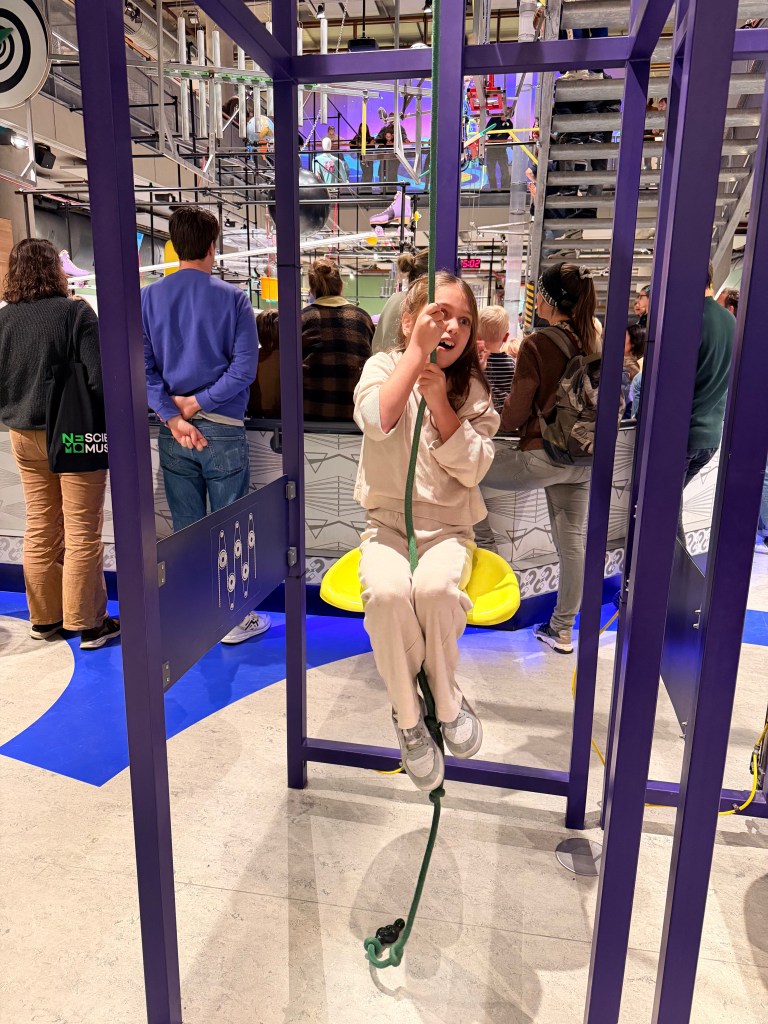 9 year old exploring a pulley seat activity at NEMO Science Museum