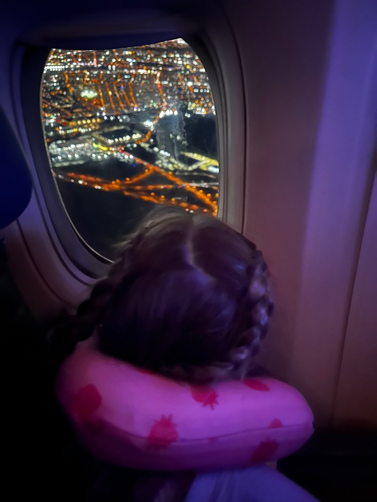 Daughter looking out airplane window when leaving Newark International Airport 