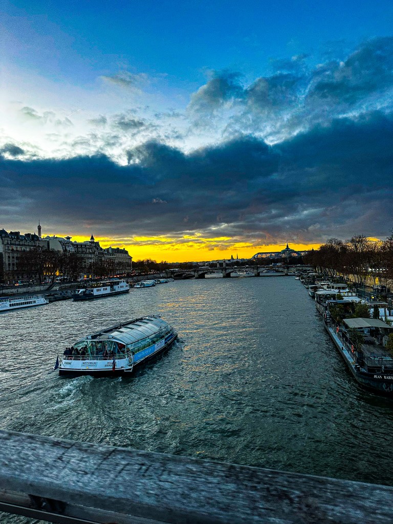 A boat traveling down the Seine River in Paris at dus