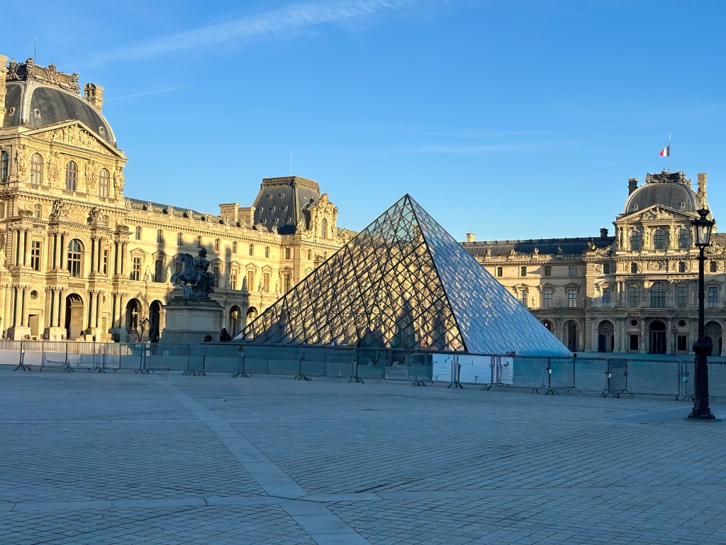 A picture of the courtyard where the glass pyramid lays at the entrance of the Louvre Museum 