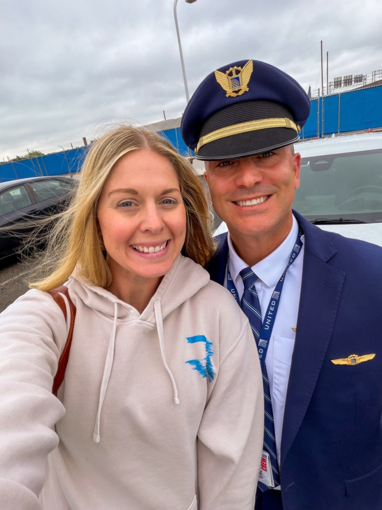 Pilot in uniform with wife in airport parking lot